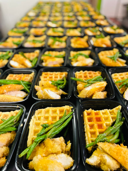 Supa Fly Chicken & Cornbread meal trays with fried chicken, cornbread waffle, and green beans ready to serve in black containers